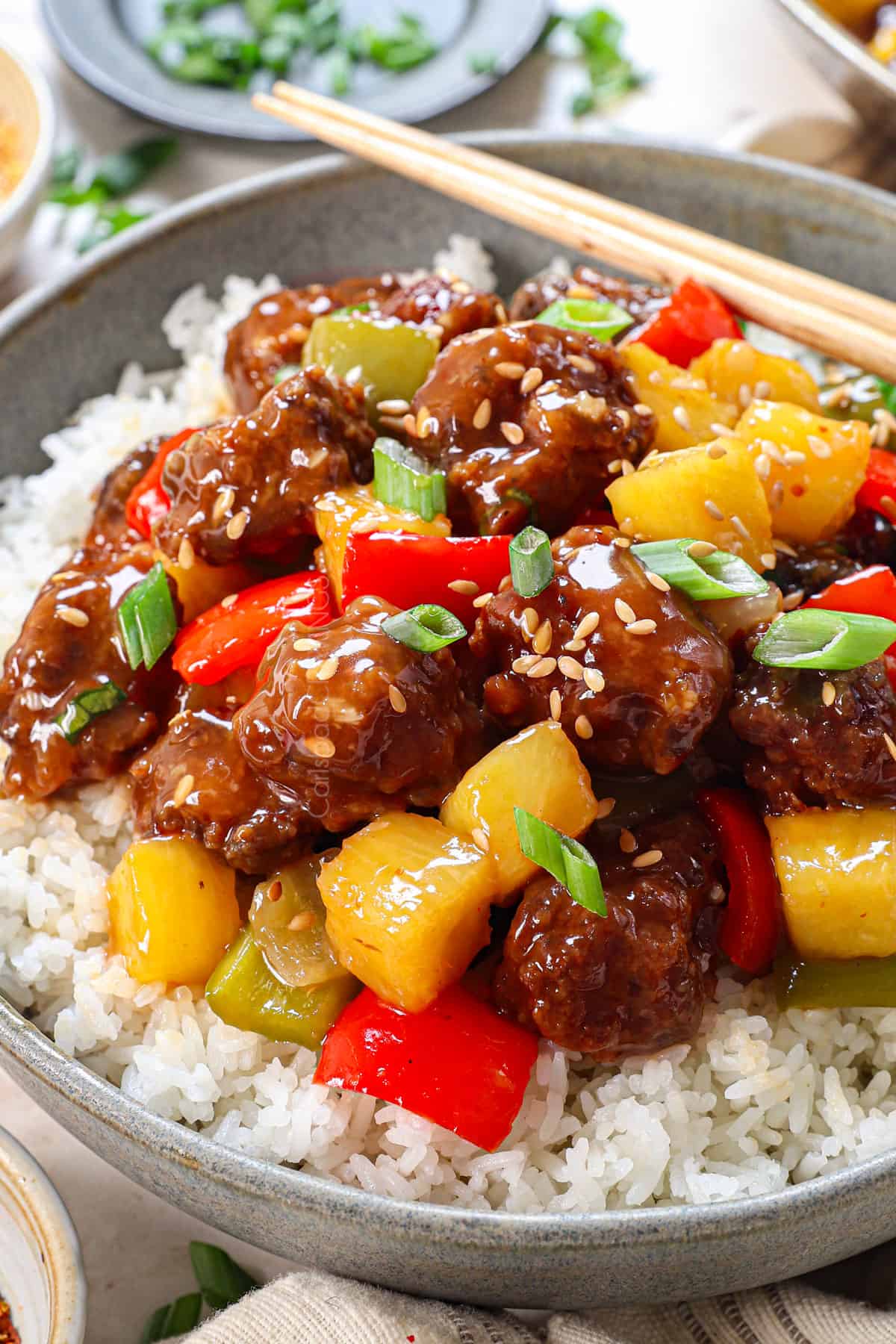 sweet and sour pork recipe being served in a bowl with rice