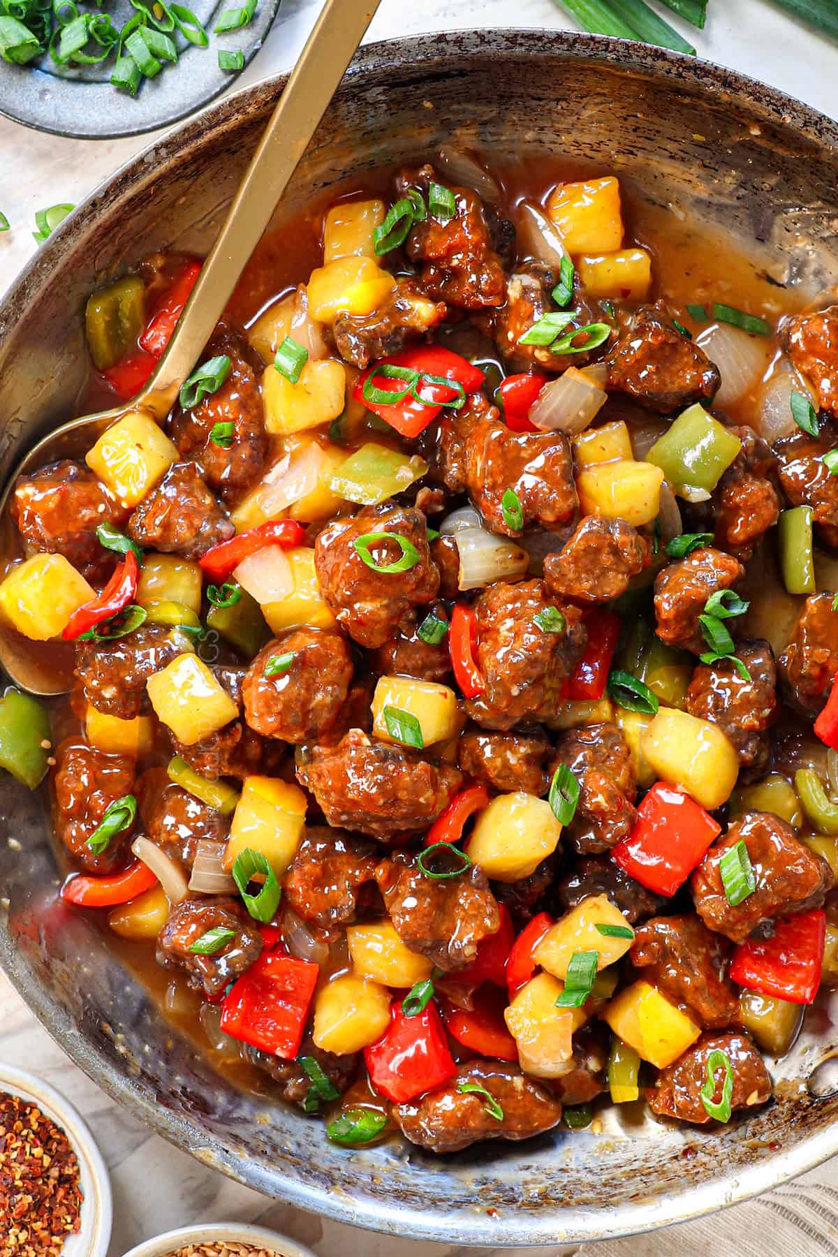 showing how to make sweet and sour pork by tossing the pork with the sweet and sour sauce