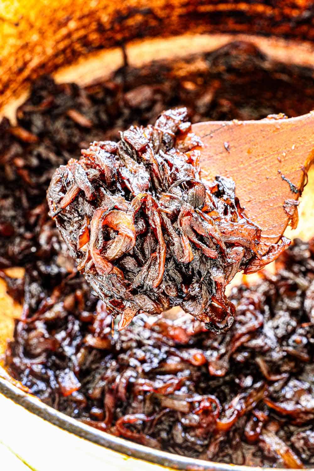 showing how to caramelize onions by scooping up onions to show the final texture after caramelizing