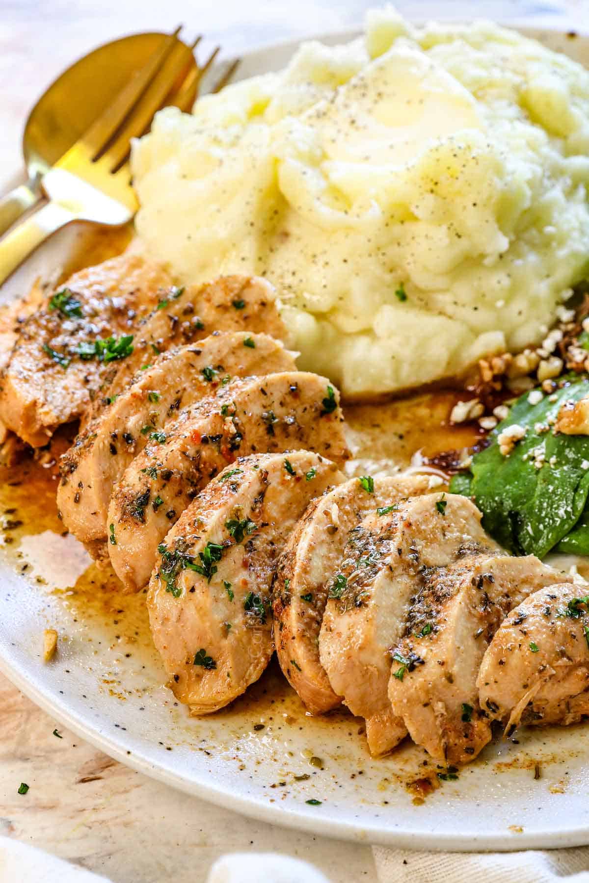 up close of slow cooker chicken recipe sliced on a plate showing how juicy it is