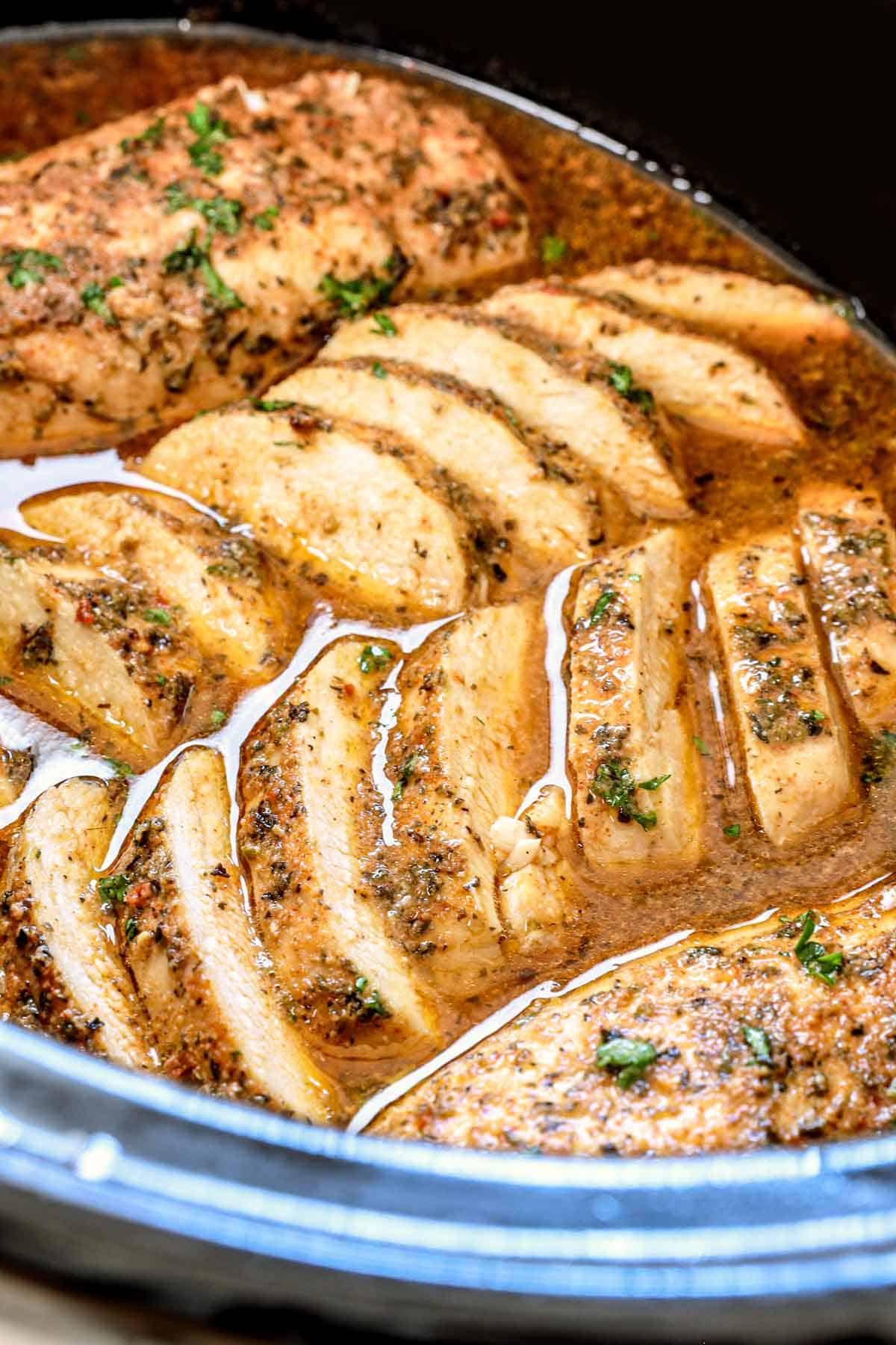 up close of crockpot chicken sliced in the crockpot showing how juicy it is