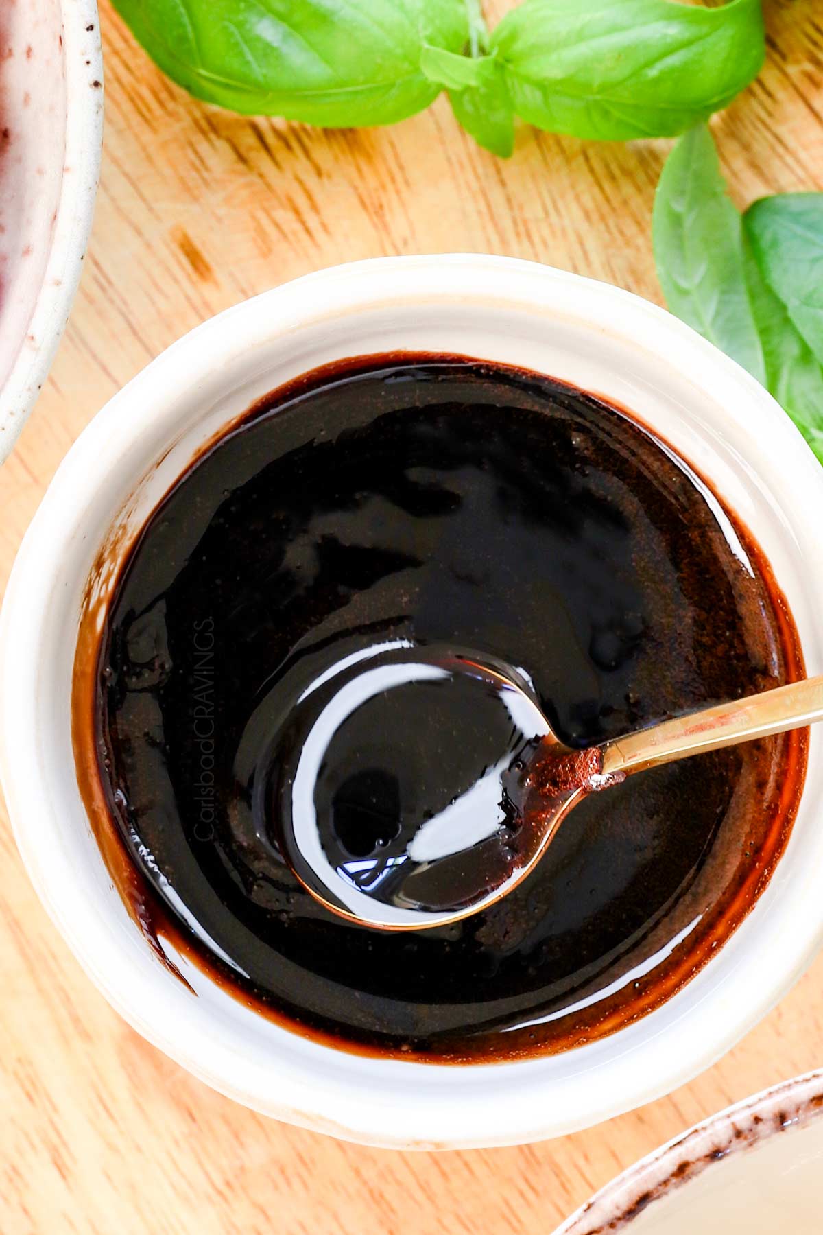 top view of balsamic glaze recipe (balsamic reduction) in a bowl with a spoon to show the thick consistency