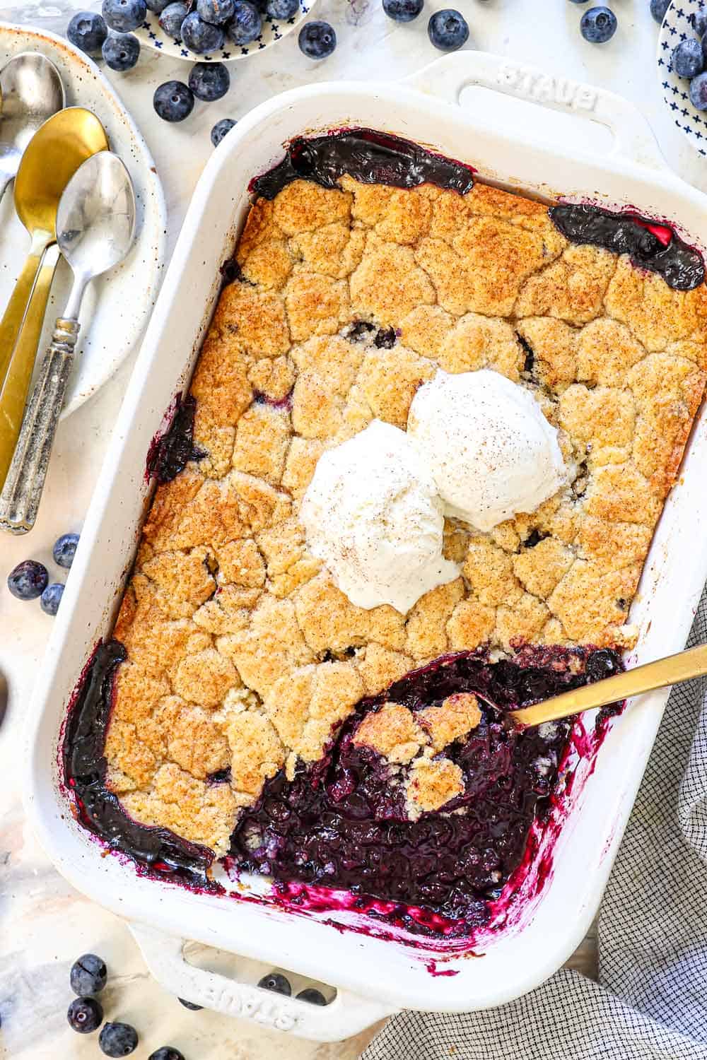 showing how to make blueberry cobbler recipe by baking until the top is golden