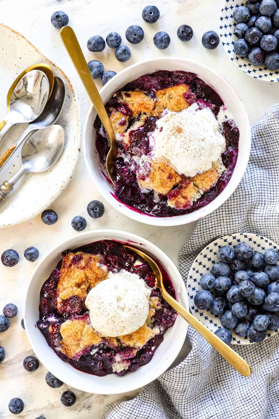 showing how to serve best blueberry cobbler recipe n two bowls with ice cream