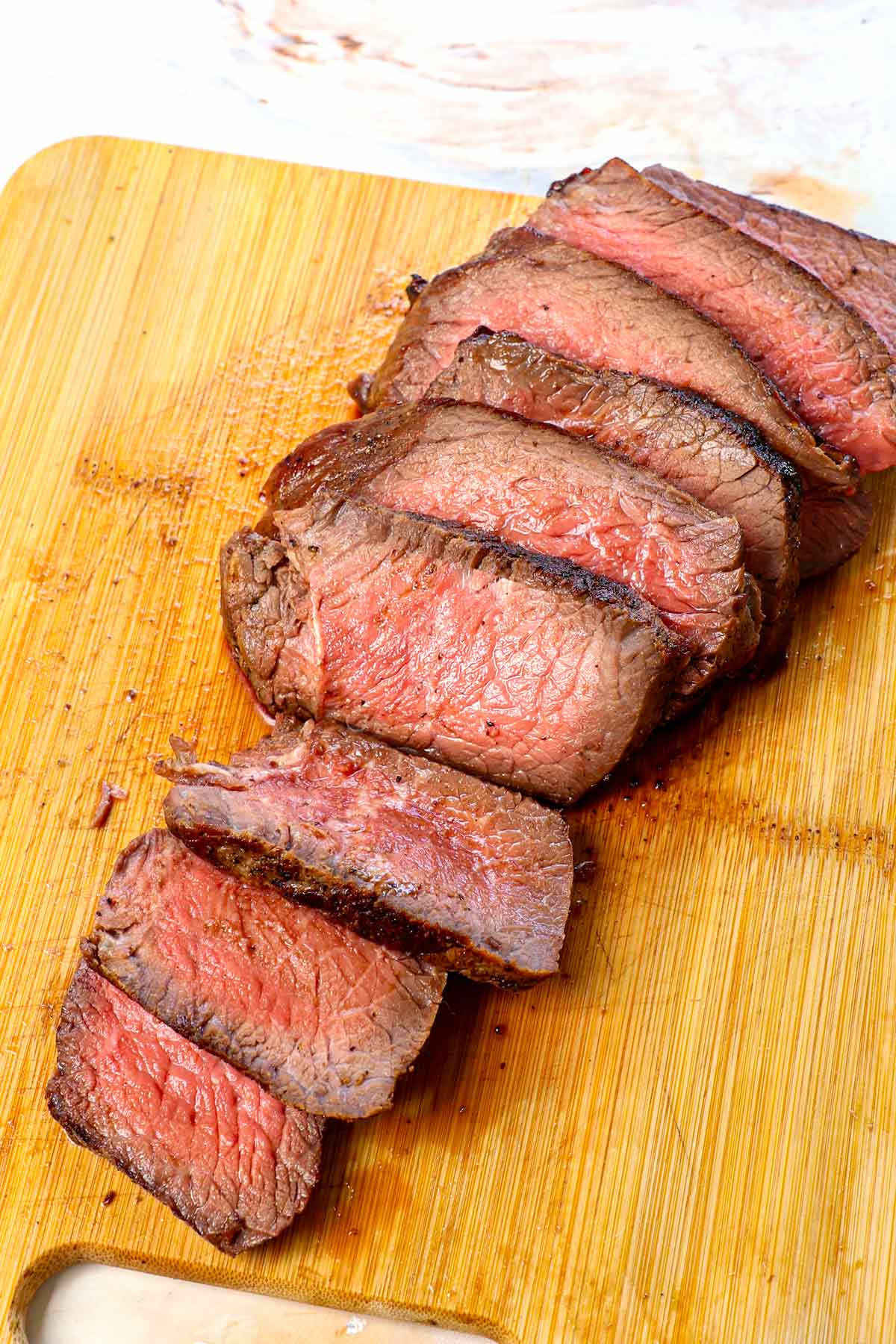 reverse steak oven sliced on a cutting board showing the perfect cook