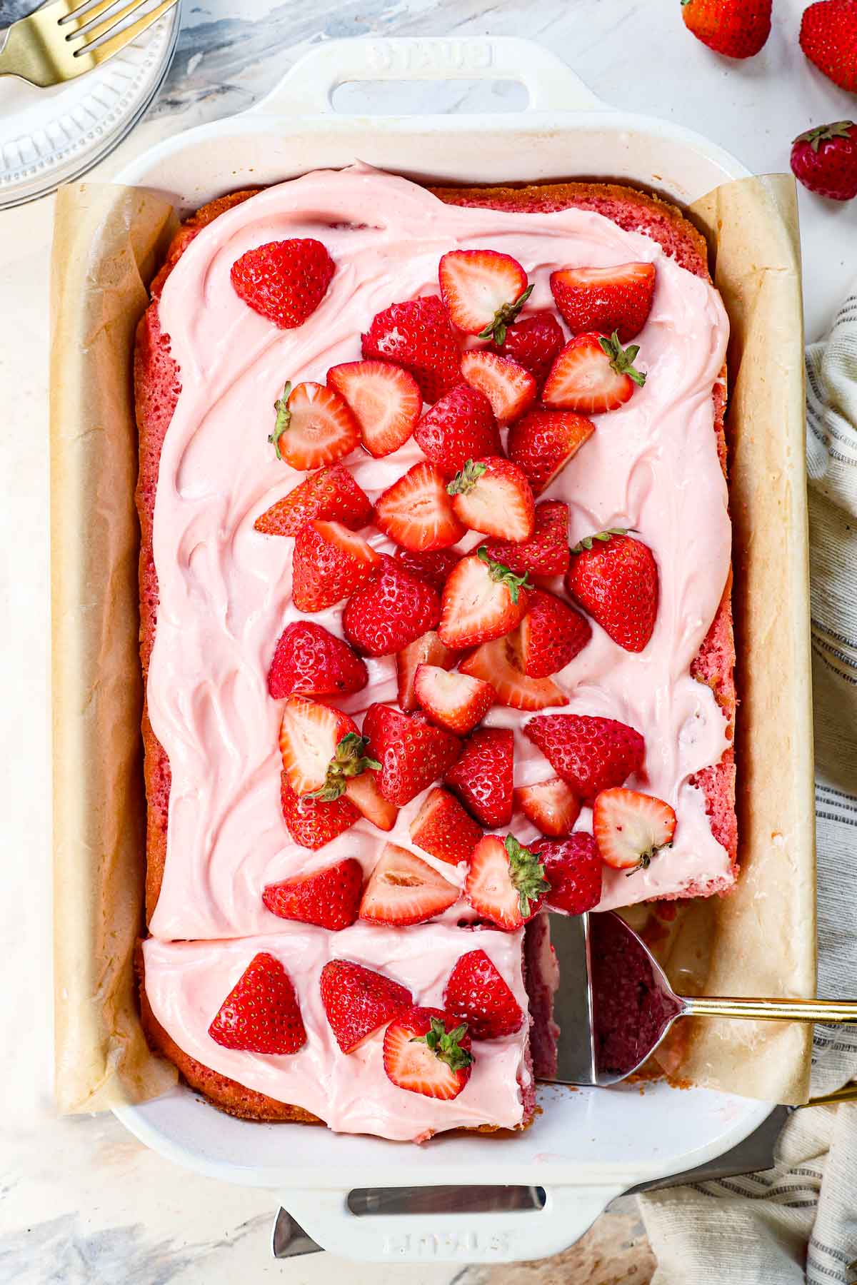 top view of strawberry cake recipe in a 9x13 pan with strawberry cream cheese frosting garnished with fresh strawberries