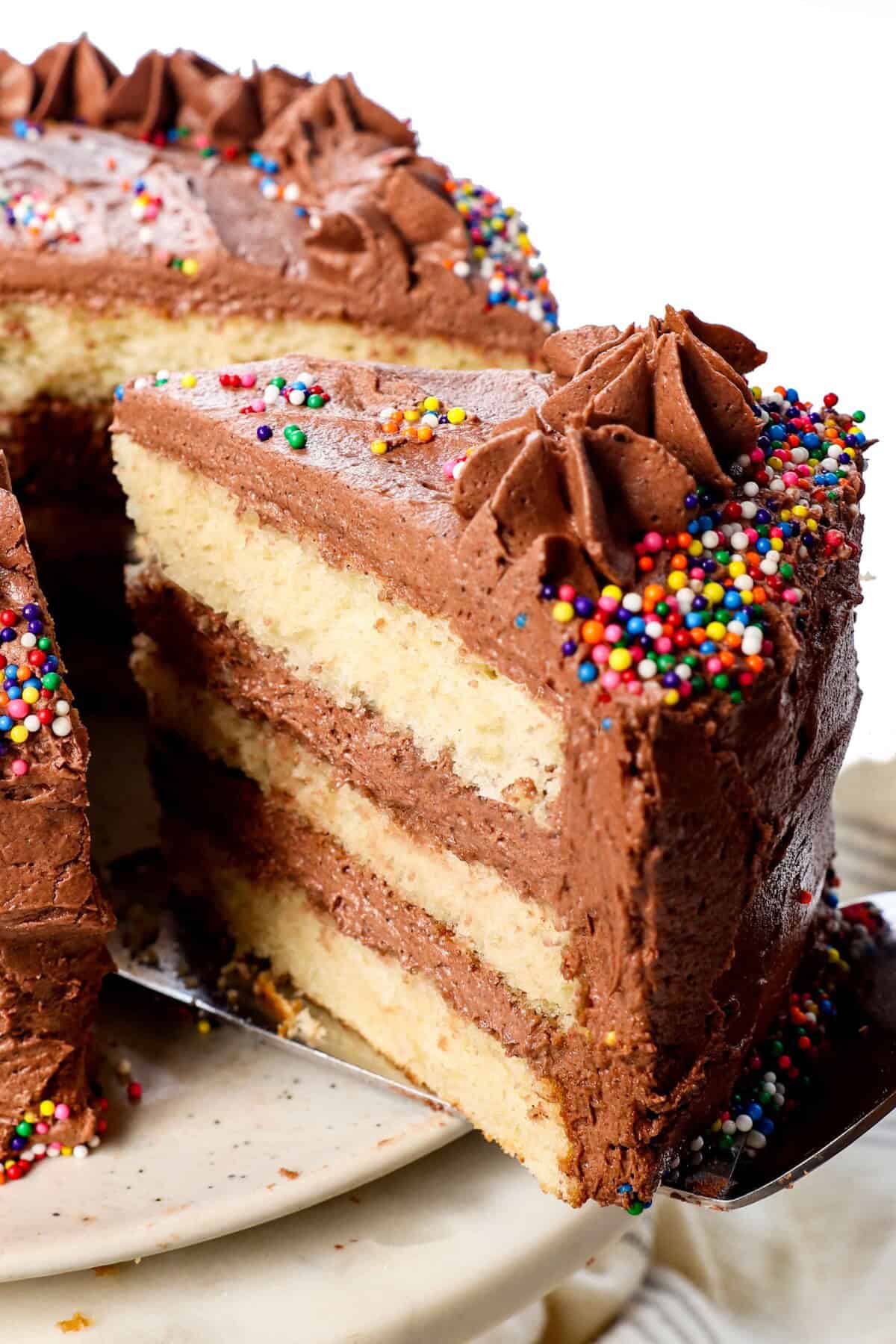 pulling out a slice of yellow cake from scratch showing the fluffy cake