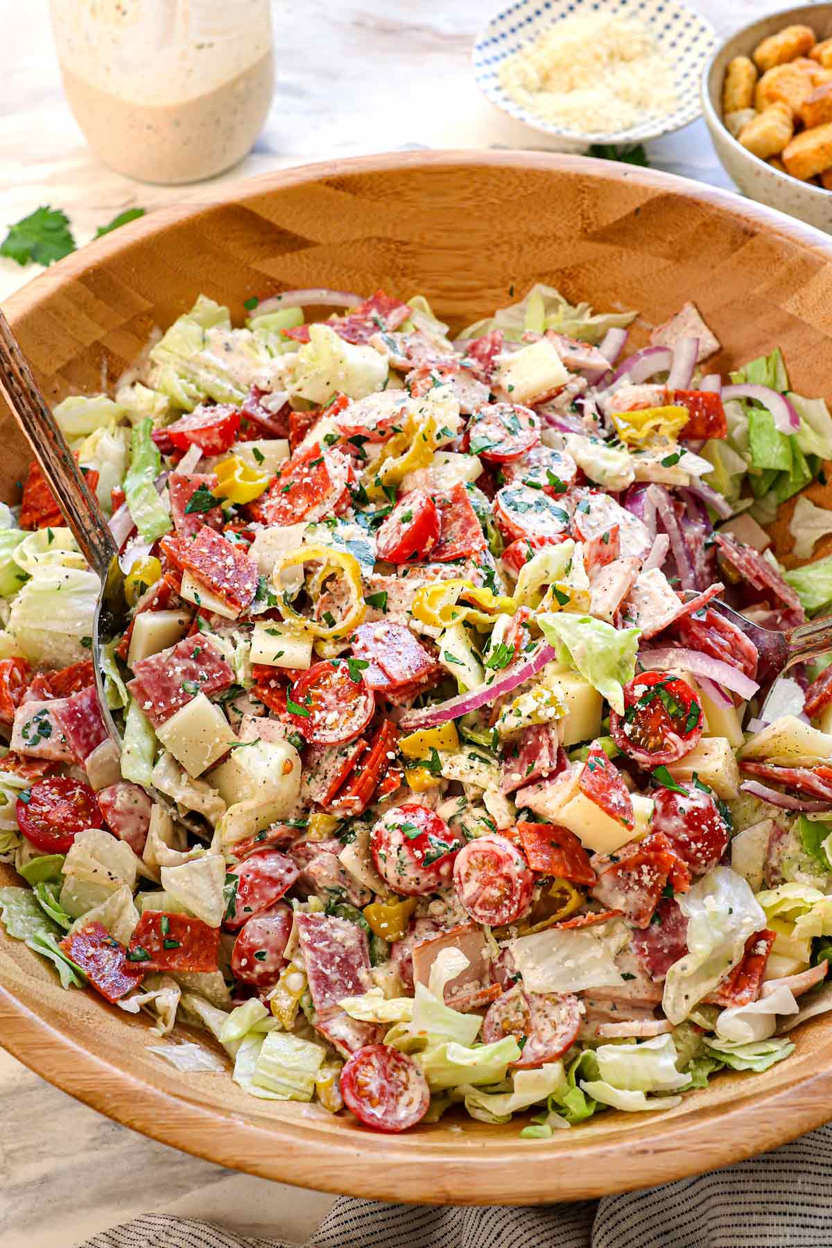 Italian Grinder Salad tossed in a wooden bowl showing all the chopped ingredients