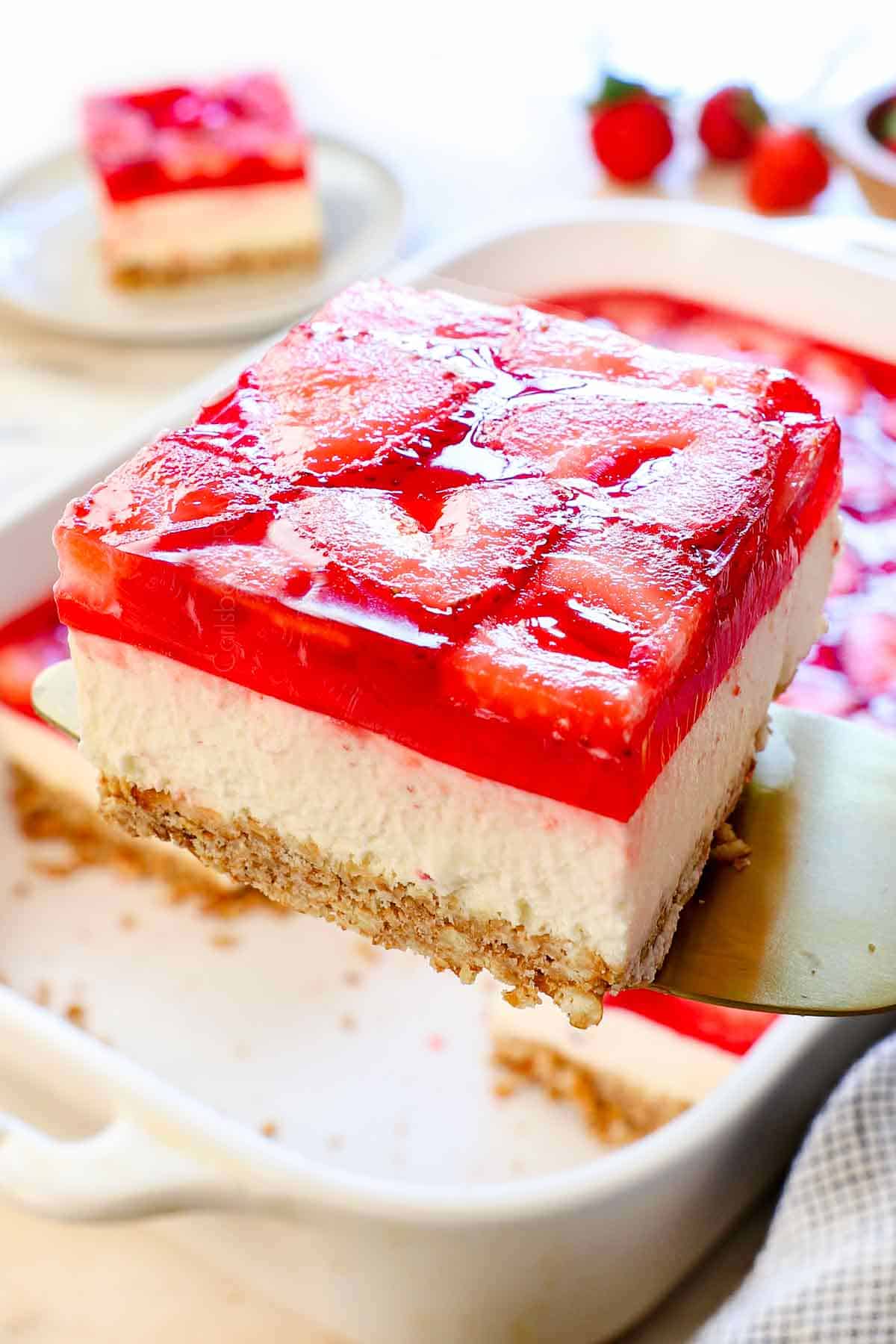 holding up a slice of strawberry pretzel salad recipe without cool whip showing the distinct layers