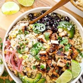 top view of street corn chicken rice bowl with Mexican street corn, Mexican chicken, cilantro lime rice, black beans, pickled red onions, cilantro, cotija and jalapeno