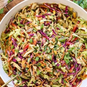 showing how to make Thai chicken salad recipe by tossing the salad with the dressing