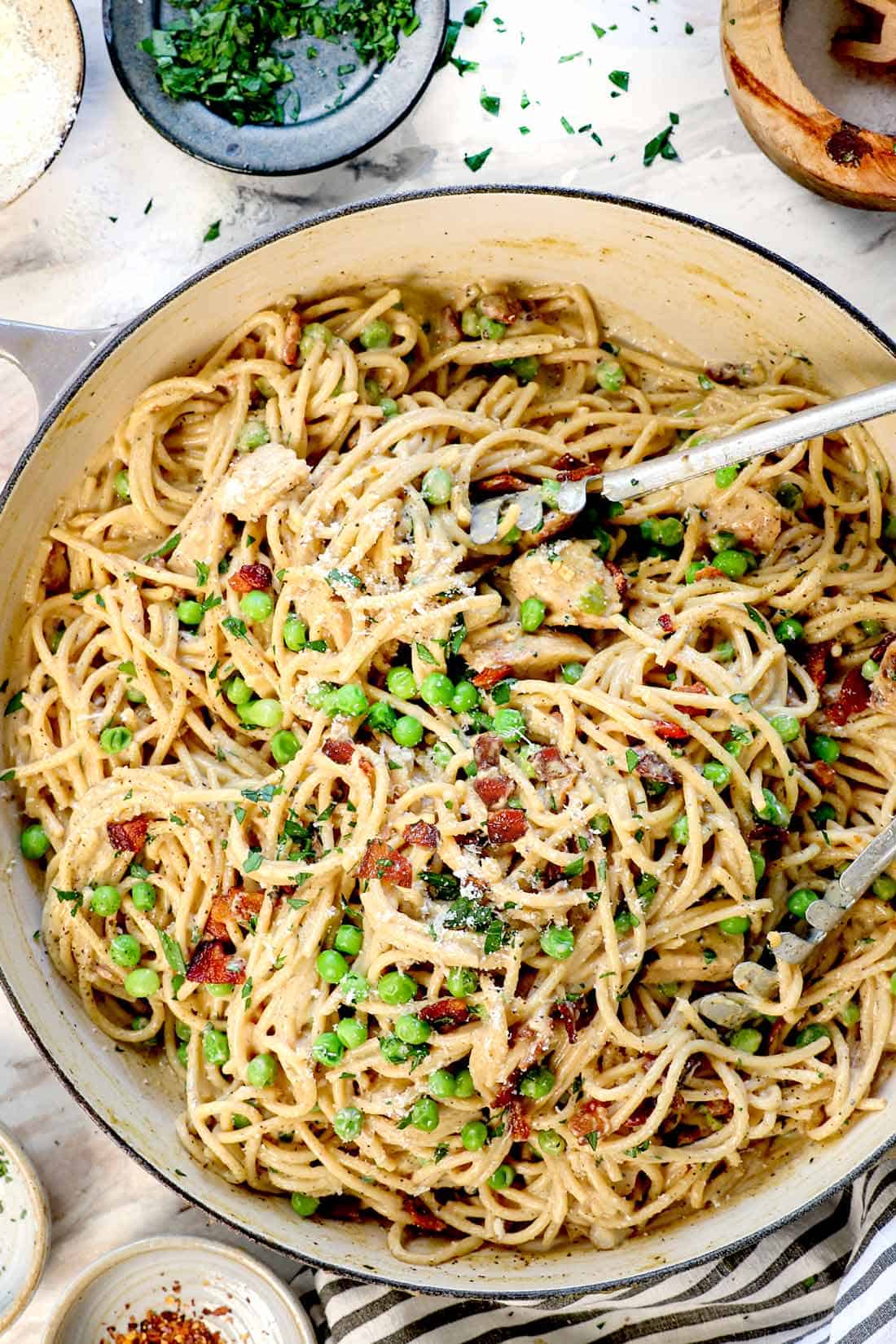 showing how to make chicken carbonara by tossing the pasta with the bacon and peas