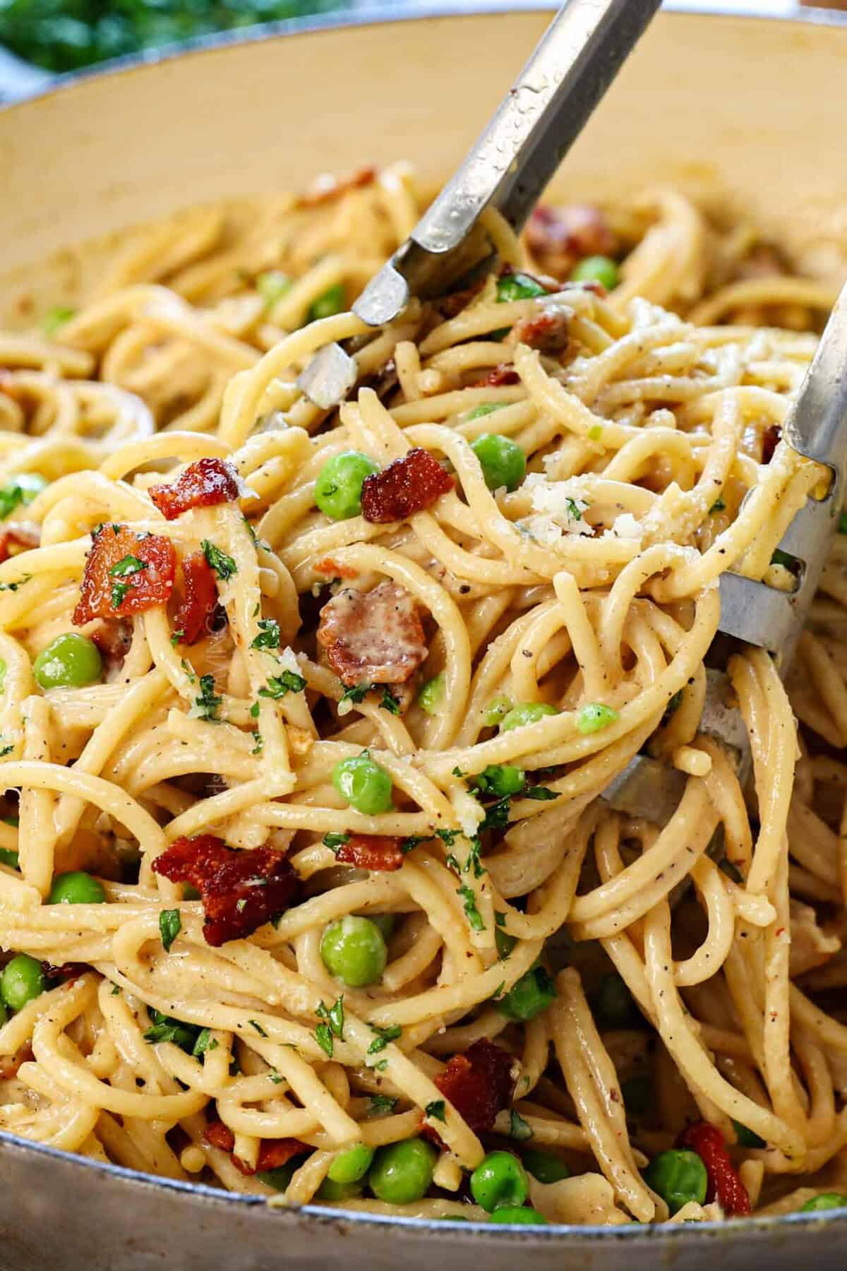 tongs picking up chicken carbonara recipe showing how creamy it is