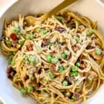 top view of chicken carbonara recipe in a bowl with a fork twirling the creamy pasta