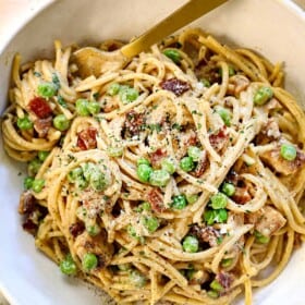 top view of chicken carbonara recipe in a bowl with a fork twirling the creamy pasta