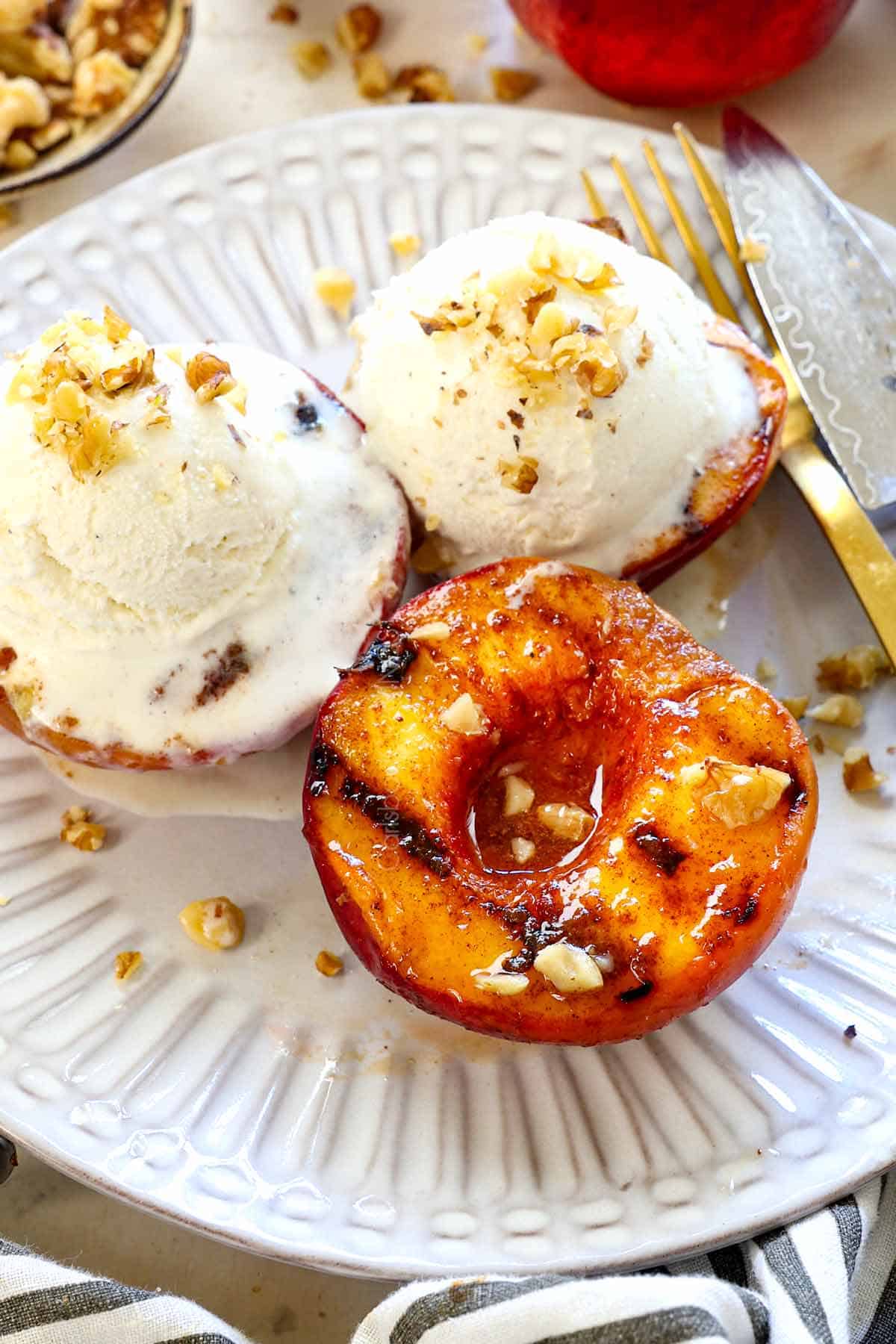 showing how to serve grilled peaches with vanilla ice cream and nuts