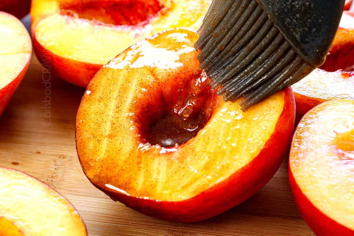 showing how to grill peaches by brushing the cut side of the peach with a mixture of melted butter, cinnamon and vanilla