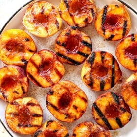 showing how to grill peaches by sprinkling with brown sugar after they are grilled