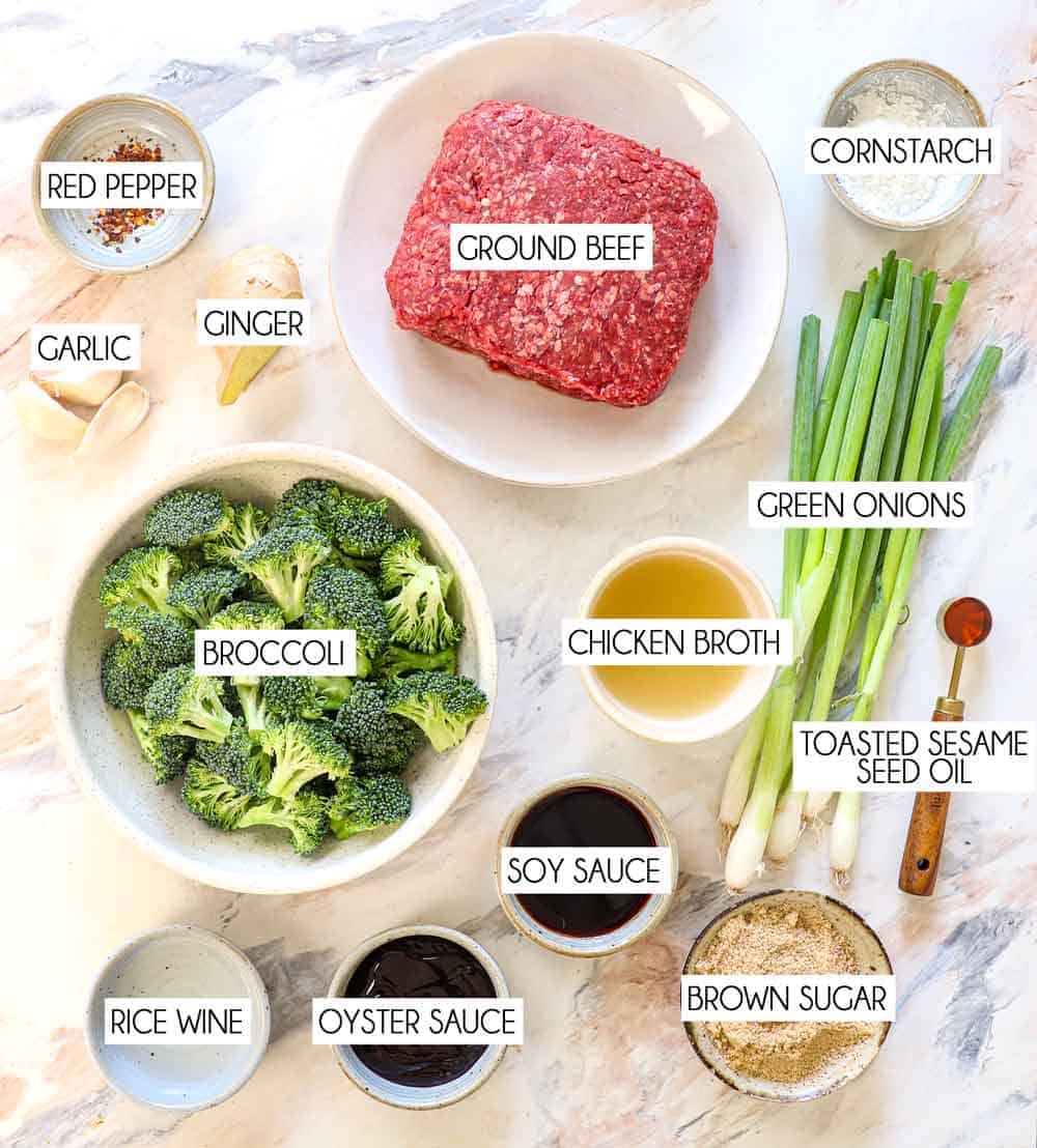 top view of ground beef and broccoli recipe ingredients: ground beef, broccoli, garlic, ginger, green onions, soy sauce, oyster sauce, chicken broth, cornstarch, toasted sesame seed oil, rice wine