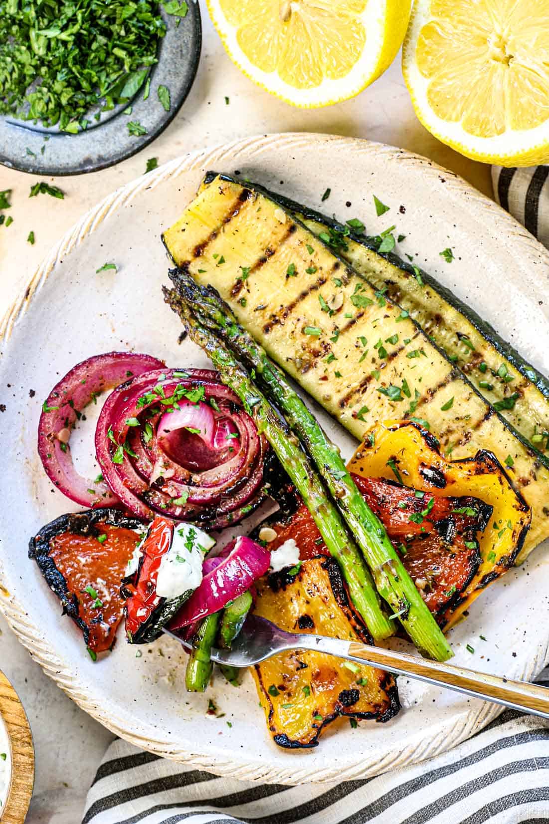 top view of best grilled vegrtables on an individual serving plate including zucchini, asparagus, bell peppers, and onions