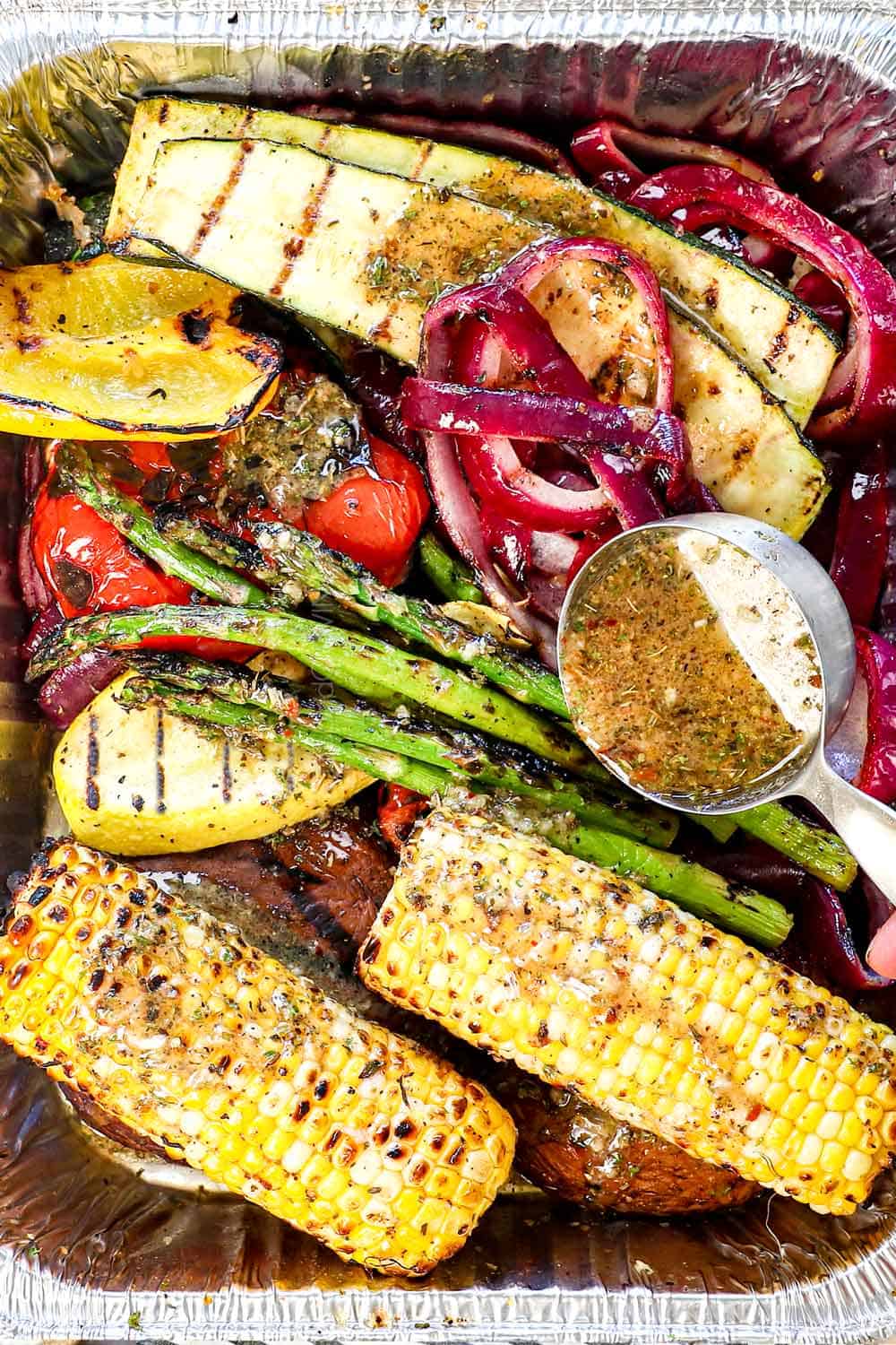 showing how to grill vegetables by drizzling with the reserved marinade/dressing as soon as they come off of the grill