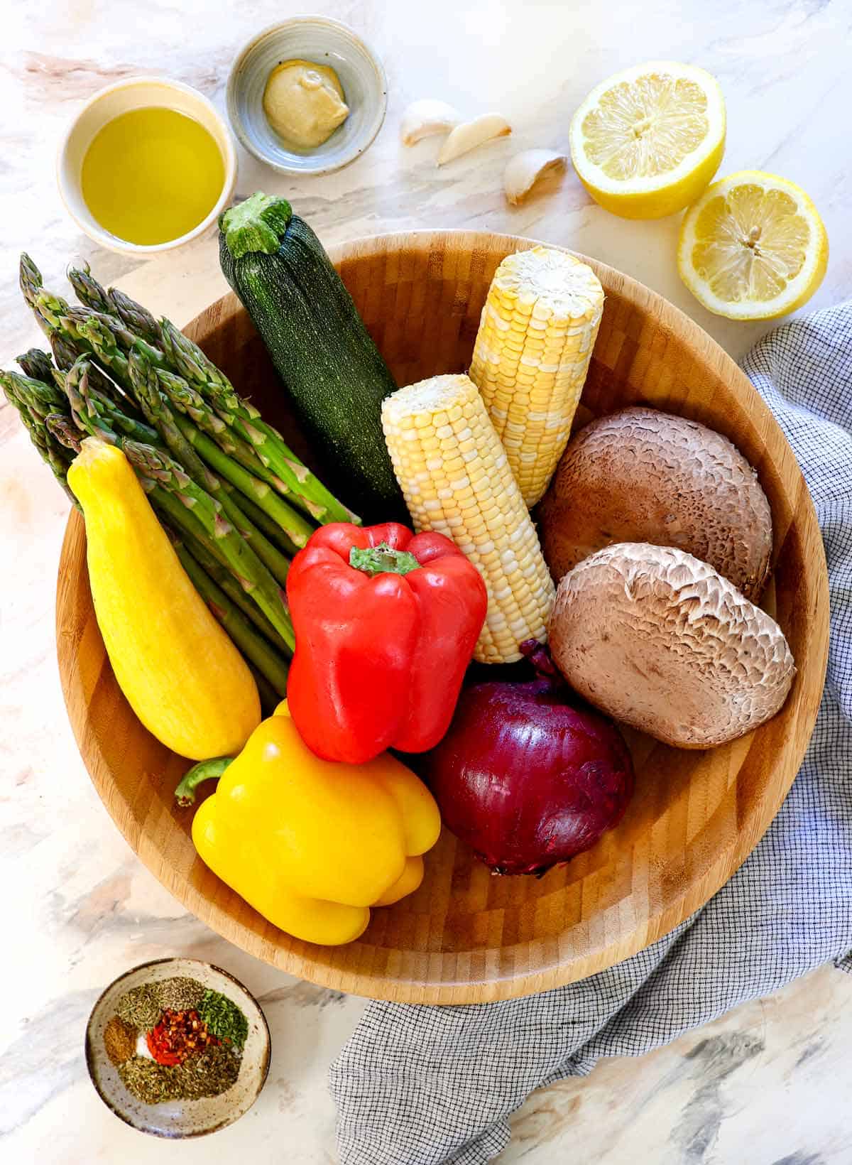top view of best vegetables to grill in a basket: zucchini, squash, bell peppers, corn, mushrooms, asparagus, corn, onions, eggplant