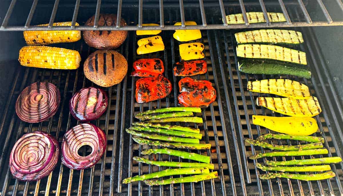 showing how to grill vegetables by grilling mushrooms, onions, bell peppers, asparagus, squash, and zucchini on the grill - the vegetables showing beautiful grill marks
