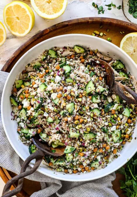Top view of Jennifer Aniston Salad in a bowl with chicken, quinoa, chickpeas, cucumbers, pistachios, feta, mint, and basil