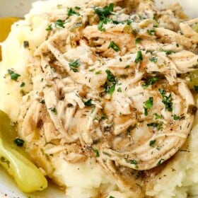 showing how to serve Mississippi chicken over mashed potatoes garnished with parsley