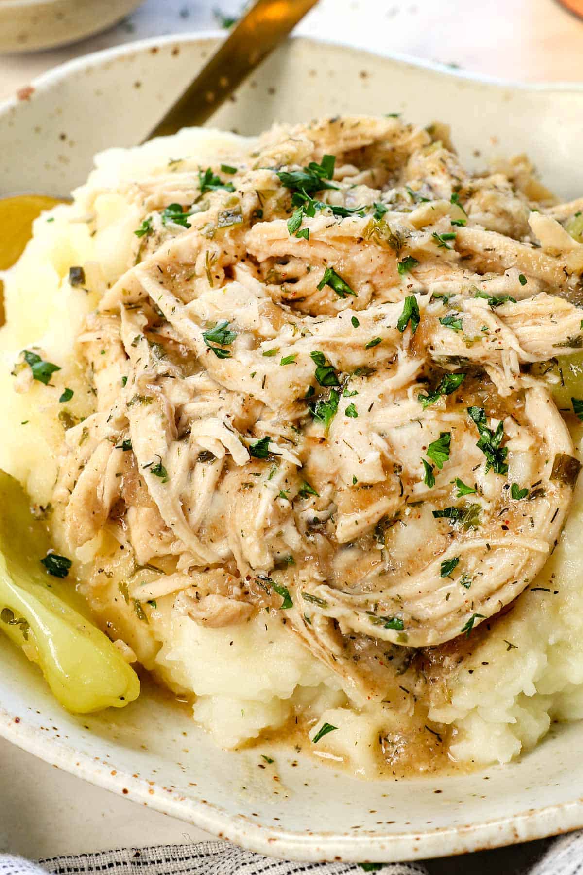 showing how to serve Mississippi chicken over mashed potatoes garnished with parsley