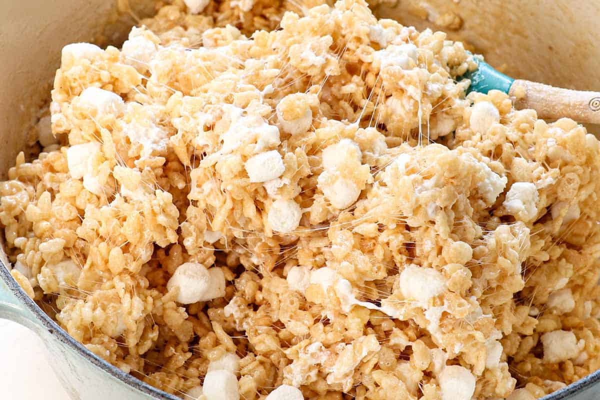 showing how to make rice krispie treats by stirring in a bag of marshmallows just until they start to melt