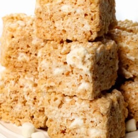 rice Krispie treats on a plate showing how chewy and gooey they are with pockets of marshmallows