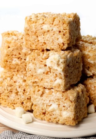 rice Krispie treats on a plate showing how chewy and gooey they are with pockets of marshmallows