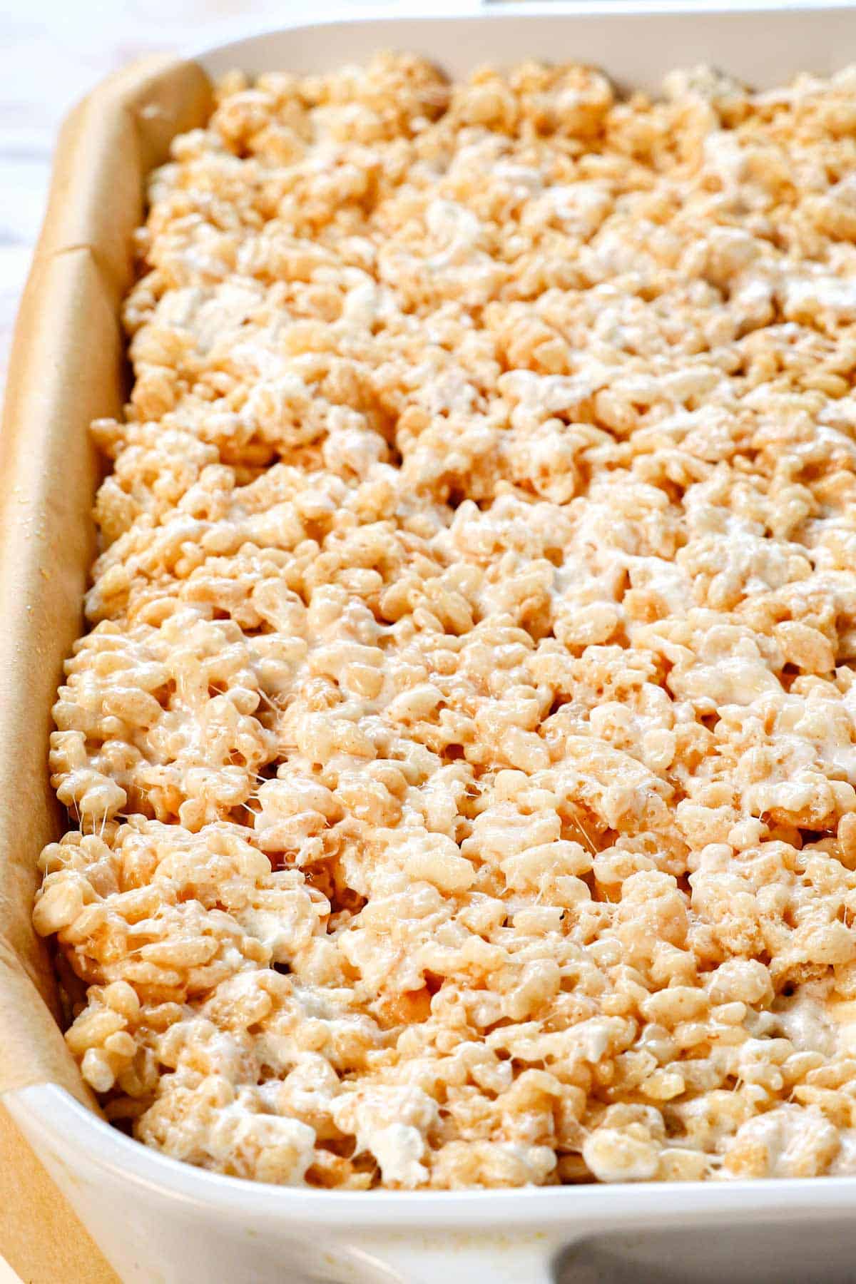showing how to make rice Krispie treats recipe by pressing into a 9x13 pan