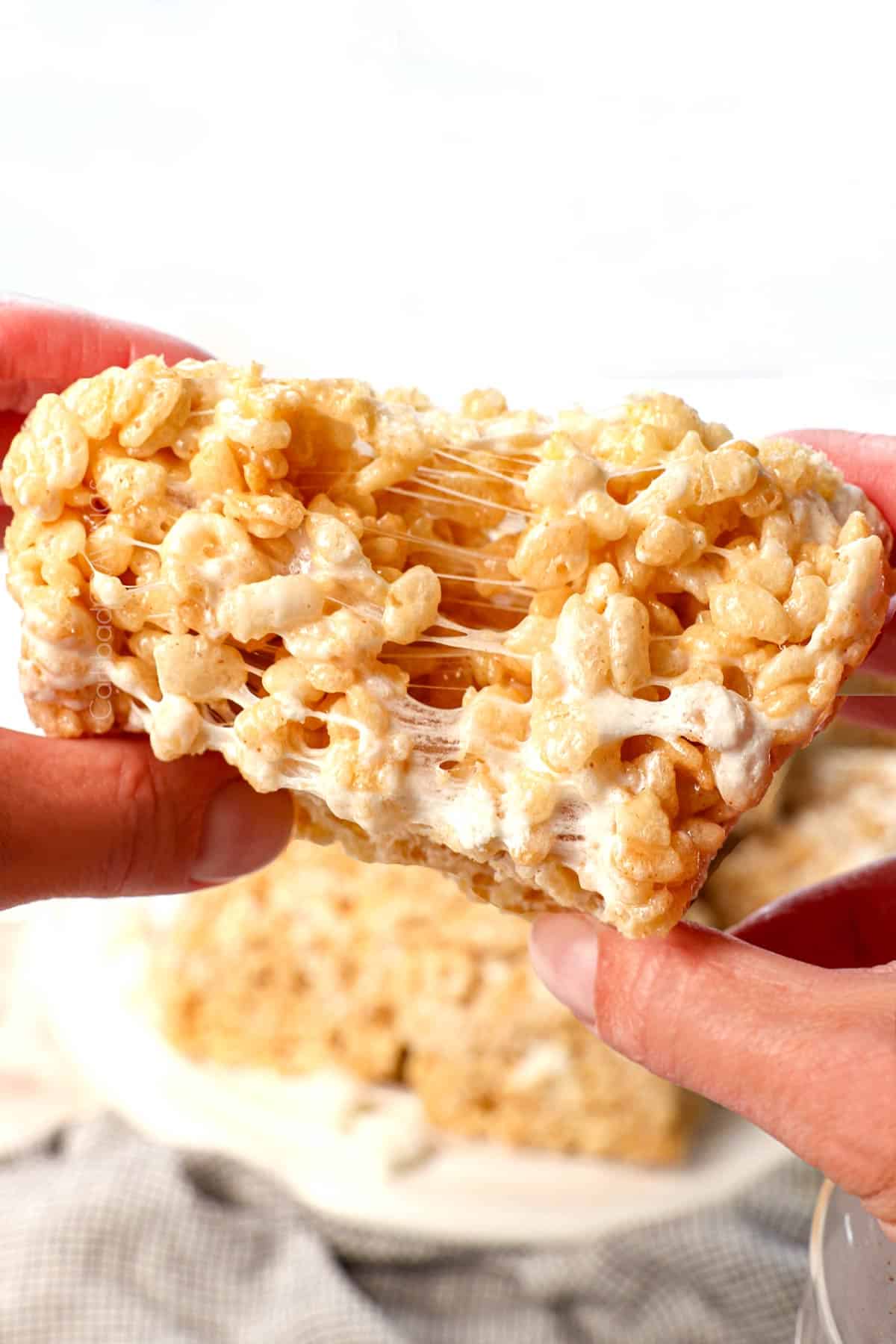 up close of pulling a rice Krispie treat apart showing how gooey they are