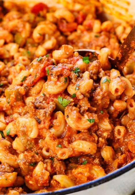 up close of scooping American chop suey showing the beef, veggies and pasta and how saucy it is