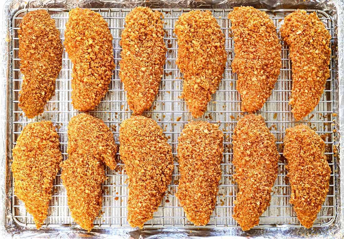 showing how to make chicken strips by lining on a baking sheet rack and baking