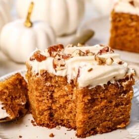 a slice of pumpkin cake with a bite taken out showing how moist it is