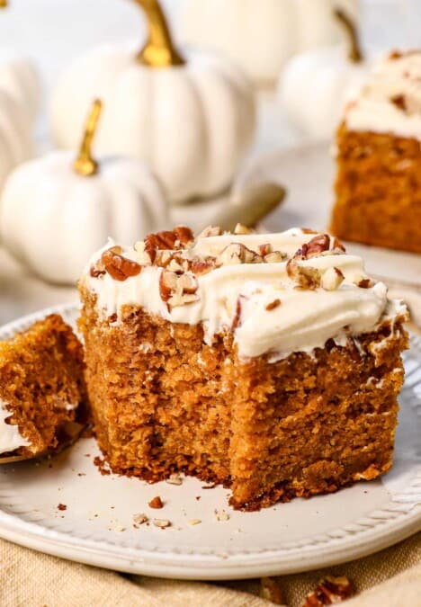a slice of pumpkin cake with a bite taken out showing how moist it is