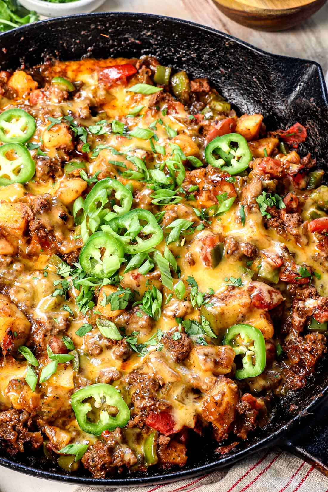 ground beef and potatoes recipe in a skillet showing how cheesy it is