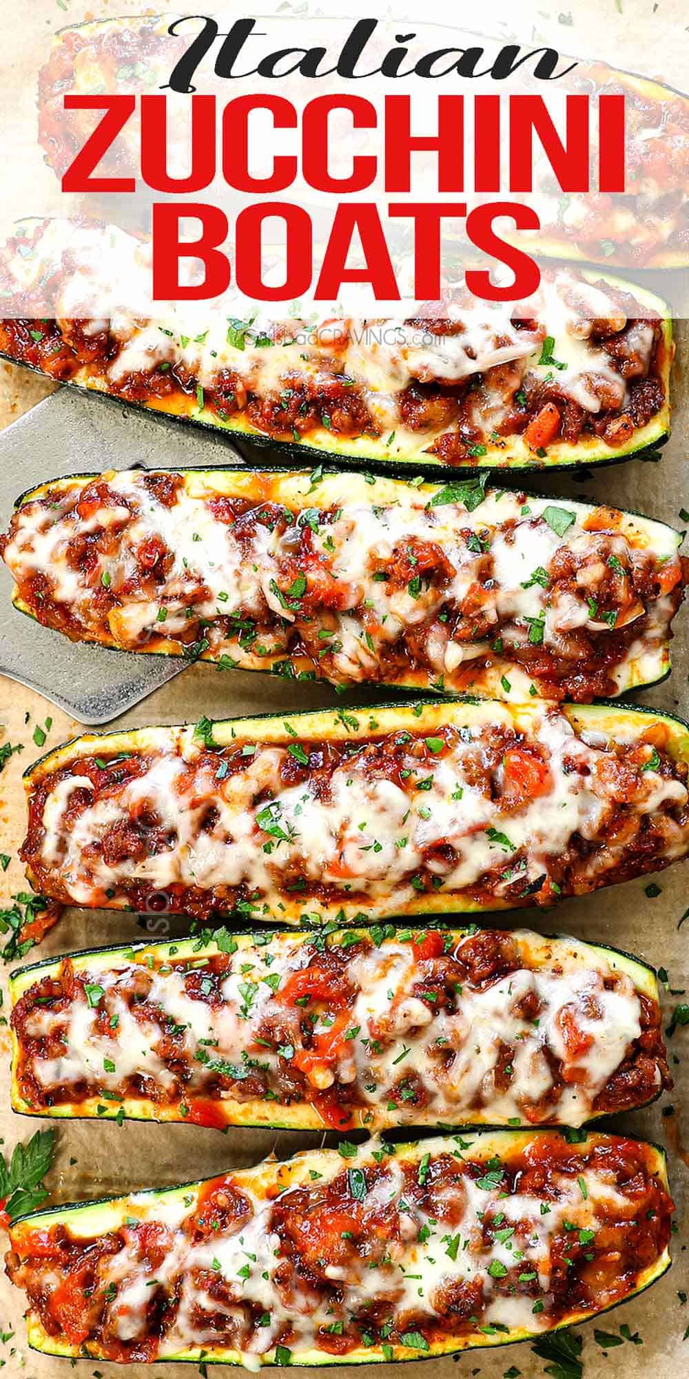 up close top view of zucchini boats lined on a baking sheet showing how cheesy they are