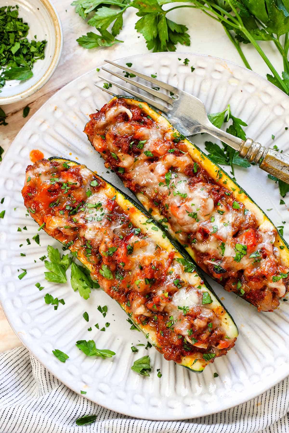 top view of zucchini boat recipe being served on a plate garnished with parsley