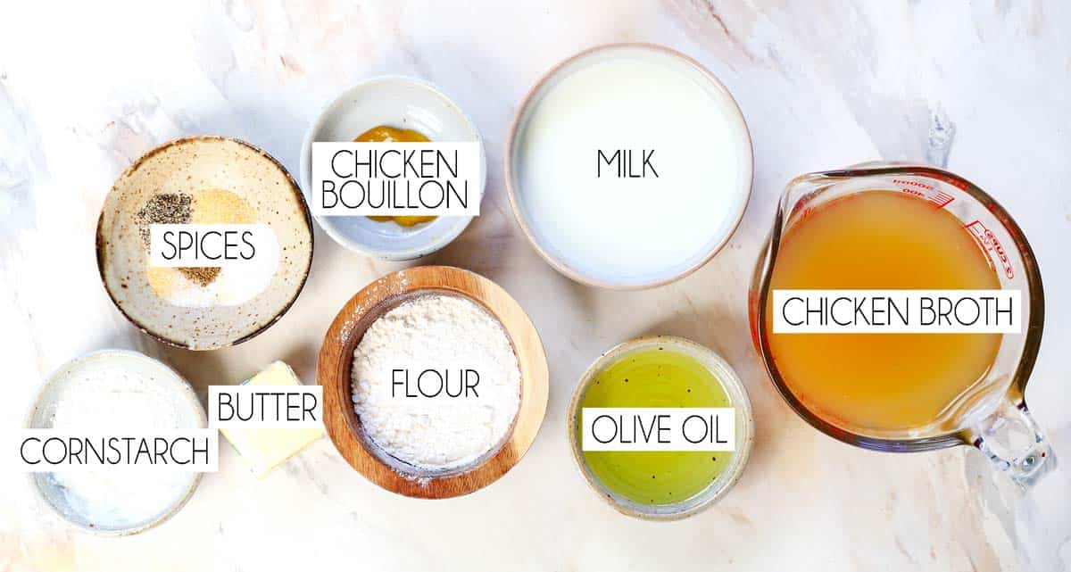 top view of cream of chicken soup ingredients: chicken broth, milk, flour, butter, olive oil, cornstarch, chicken bouillon, garlic powder, onion powder, salt, pepper, and celery seed