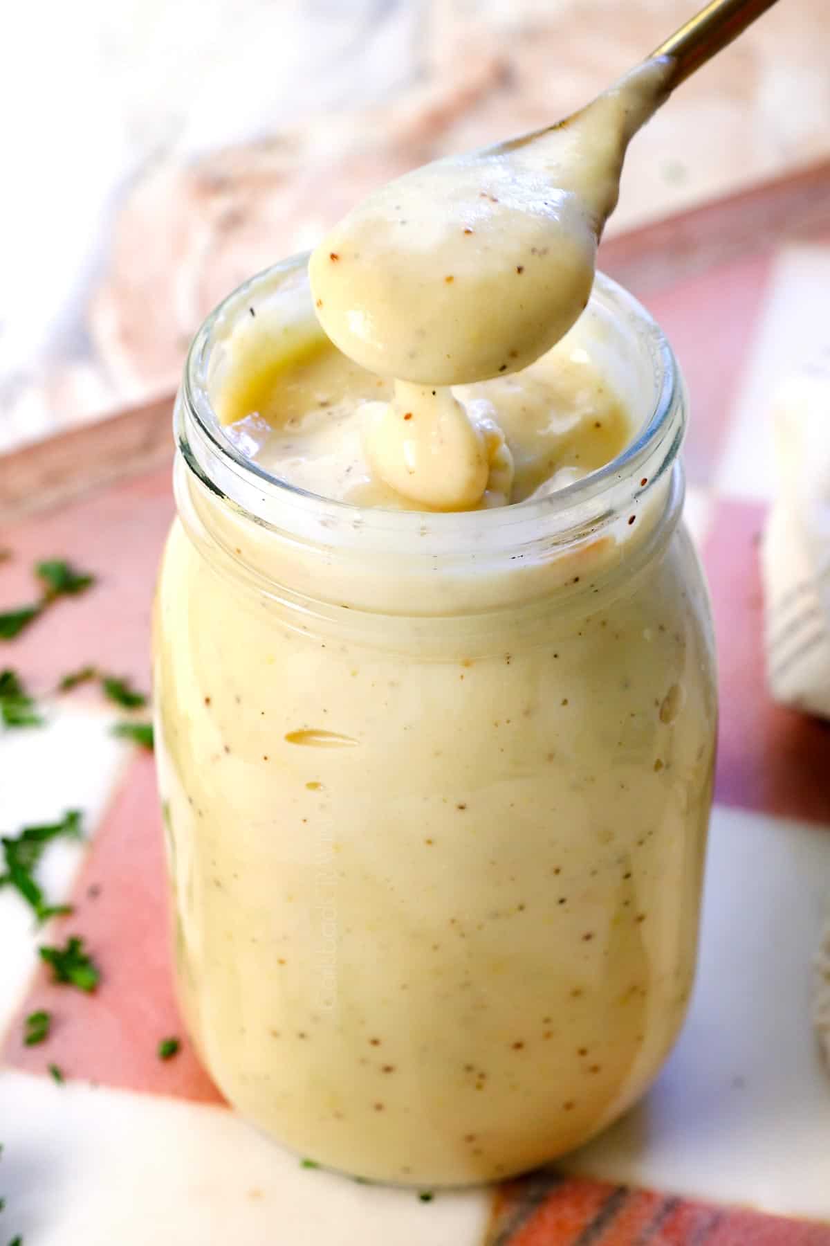 homemade cream of chicken soup being lifted up by a spoon to show the smooth, creamy, consistency