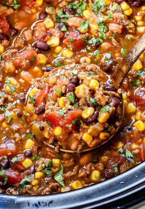 up close of a scoop of slow cooker taco soup showing the ground beef, beans corn, tomatoes