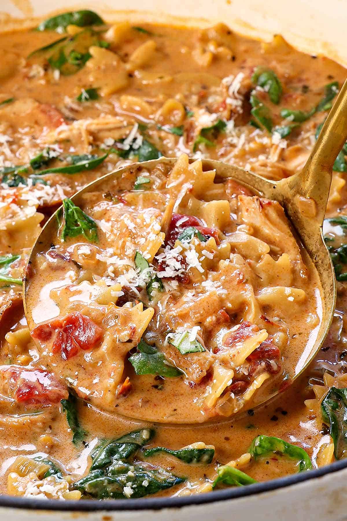 up close showing how to make Marry Me Chicken Soup by garnishing with Parmesan and basil