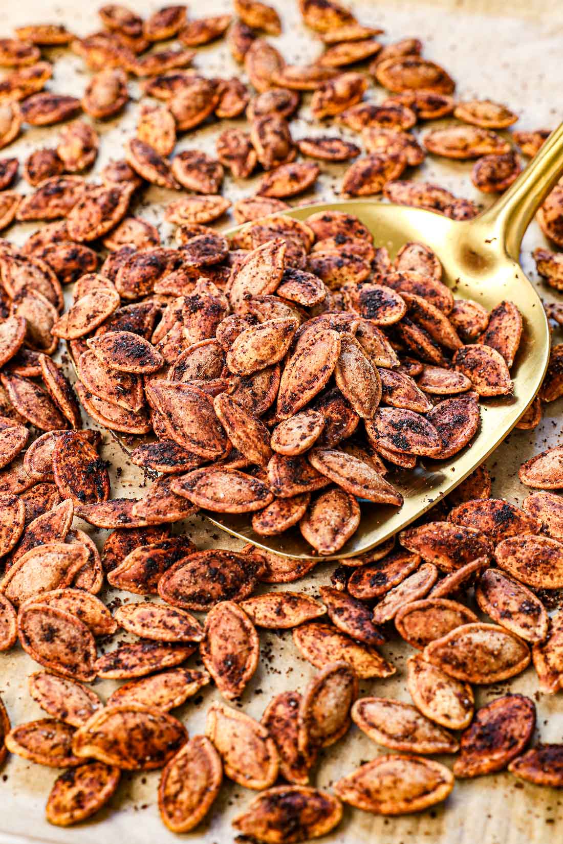 up close of scooping up roasted pumpkin seeds to show how crispy they are and well seasoned